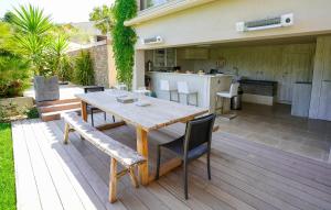 a wooden table and chairs on a wooden deck at villa Sant-Anna in Saint-Tropez