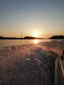 a body of water with the sunset in the background at Casa Iris Murighiol in Murighiol
