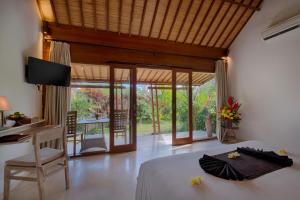 una camera con letto, scrivania e tavolo di Villa Tegal Tis Ubud - CHSE Certified a Payangan