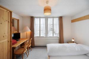 1 dormitorio con 1 cama y escritorio con ordenador en Hotel Krone Budget, en Lenk