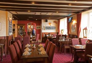 a dining room with tables and chairs in a restaurant at Anchor Inn by Greene King Inns in Beer
