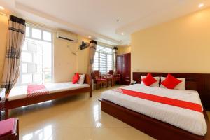 a bedroom with two beds with red pillows at TITANIC HOTEL in Hanoi