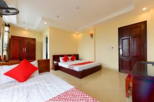 Habitación de hotel con cama con almohadas rojas en TITANIC HOTEL, en Hanói