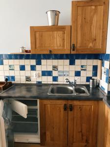 una cucina con lavandino e piastrelle bianche e blu di Apartament Regata w sercu Mariny w Ustce a Ustka