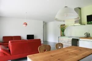 a living room with a red couch and a table at Ferien am Wolfsbach in Lindau