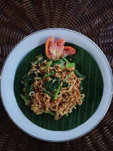 a plate of food with noodles on a banana leaf at Argasoka Bungalows in Ubud
