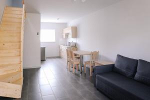 a living room with a couch and a table and a kitchen at 7a KLIMA in Ślesin
