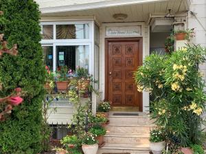 伊斯坦布尔伊斯坦布尔阿达酒店的一座种植了盆栽植物的房屋和一扇木门