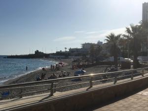 una playa con gente sentada en la arena y el agua en Casa del Mar 1, en Nerja