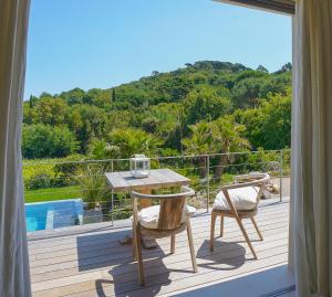 a patio with a table and chairs on a deck at villa Sant-Anna in Saint-Tropez
