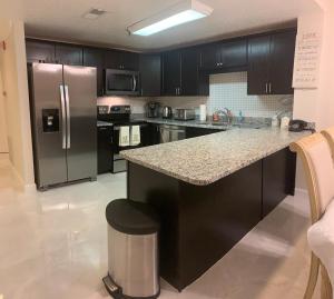a kitchen with black cabinets and a stainless steel refrigerator at Luxury condo in the heart of Pigeon Forge in Pigeon Forge