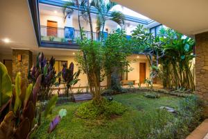 a garden in the middle of a building with plants at Svarna Hotel in Sanur