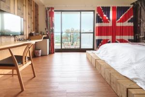 安平的住宿－異宿風巢景觀旅店 ，一间卧室配有一张带书桌和国旗的床