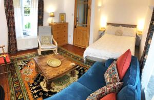 a living room with a bed and a blue couch at Central Boscastle studio flat in Boscastle
