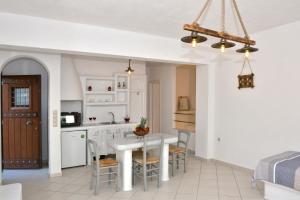 a kitchen and dining room with a white table and chairs at Naxian vacation with sea view in Naxos Chora
