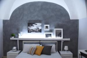 a bedroom with a bed with a gray wall at Sotto il Duomo in Catania