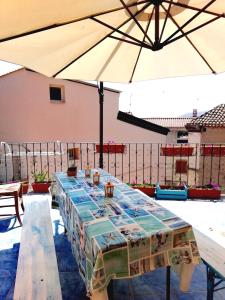 einen großen Tisch mit Sonnenschirm auf einer Terrasse in der Unterkunft Casa di Eugenia in Loceri
