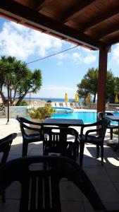 a patio with a table and chairs next to a swimming pool at Villaggio Mascia in Vieste