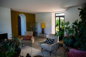 a living room with chairs and potted plants at Côté Jardin, Chambres d’hôtes B&B in Le Pont-de-Beauvoisin