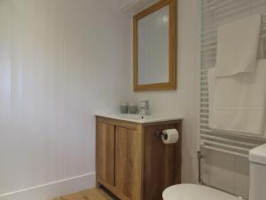 a bathroom with a sink and a toilet and a mirror at White Willows in Praa Sands