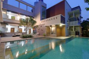 a swimming pool in front of a house at Mutiara Suites in Jakarta