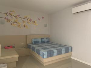 um quarto com uma cama e um quadro na parede em Merry Resort Photaram em Ban Khlong Ta Khot