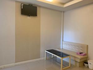 um quarto com uma mesa e uma televisão na parede em Merry Resort Photaram em Ban Khlong Ta Khot