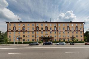 un gran edificio con coches estacionados frente a él en Yaroslavskaya Hotel, en Moscú