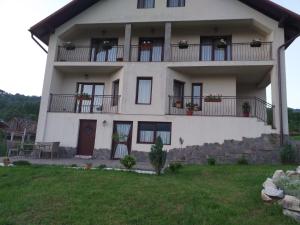 a large white house with balconies and a yard at Vila Puiu Borsa MM in Borşa
