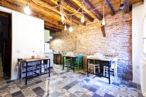 キオッジャにあるB&B LA CANEVA 951のテーブルと椅子が備わるレンガの壁の客室です。