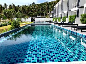 a swimming pool with blue tiles in a resort at The Blue Lotus in Mae Nam
