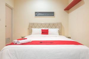 a bedroom with a large white bed with red pillows at RedDoorz At Tebet Barat 2 in Jakarta