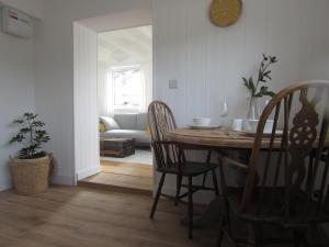 sala de estar con mesa, sillas y sofá en White Willows, en Praa Sands