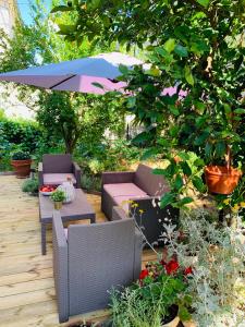 um pátio com cadeiras, uma mesa e um guarda-sol em Apartment Ivica em Trogir