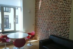 a room with a brick wall and a table and chairs at Suite Louise-Stephanie Brussels in Brussels