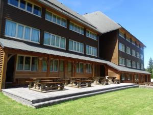 a building with picnic tables in front of it at Studio Lou Kiwi - Résidence Bec de l Aigle in Le Lioran