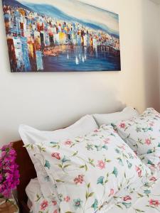uma cama com almofadas brancas e um quadro na parede em Apartment Ivica em Trogir