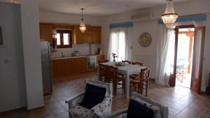 kuchnia i jadalnia ze stołem i krzesłami w obiekcie Oros Villas w mieście Axós