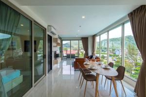 a dining room and living room with a table and chairs at Oceana Sea View Apartments - Kamala Beach in Kamala Beach