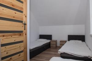 two beds in a room with a door open at Przystanek Jarosławiec in Jarosławiec