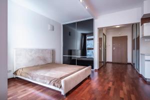 1 dormitorio con 1 cama grande y suelo de madera en Apartament Gdański, en Varsovia