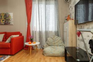 a living room with a red couch and a table at Alionas home in Tbilisi City