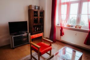 a living room with a chair and a television at TATRYSTAY Apartment Milo in Nový Smokovec