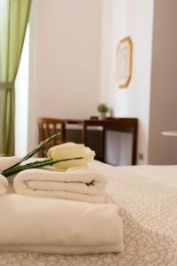a hotel room with towels and a flower on a bed at Santa Croce Exclusive in Florence