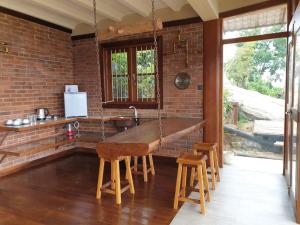 uma cozinha com uma parede de tijolos e uma mesa de madeira em The Cloud Resort em Kadugannawa