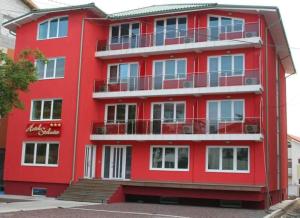 a red apartment building with a redventh floor at Steluta in Eforie Nord