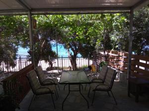 patio ze stołem, krzesłami i ogrodzeniem w obiekcie Ionion Beach House w mieście Ligia