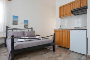 a small kitchen with a bed and a refrigerator at Margarita in Perissa