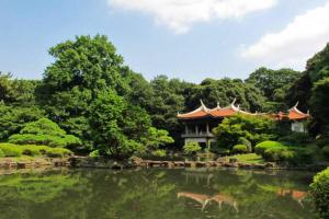 a building next to a pond in a garden at Chiba Breen hills Inage #8Mx in Chiba