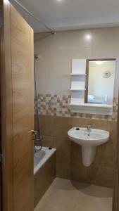 a bathroom with a sink and a mirror at APARTAMENTOS EL SOLO in Santillana del Mar
